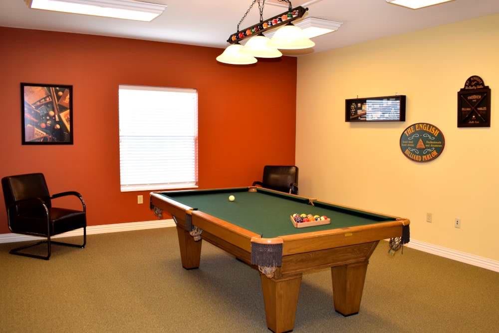 A cozy game room featuring a pool table and warm-colored walls.