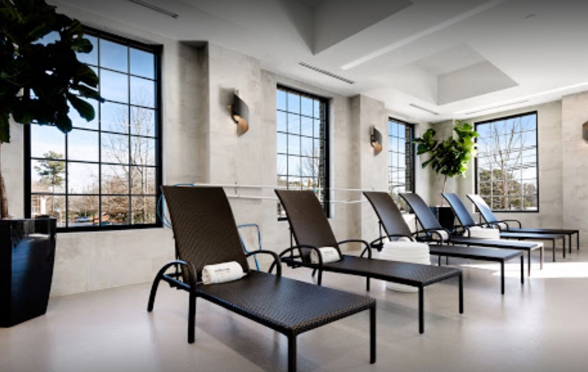 A modern relaxation area with lounge chairs and large windows.