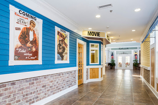 A vibrant corridor showcasing vintage movie posters against a blue wall with brick accents.