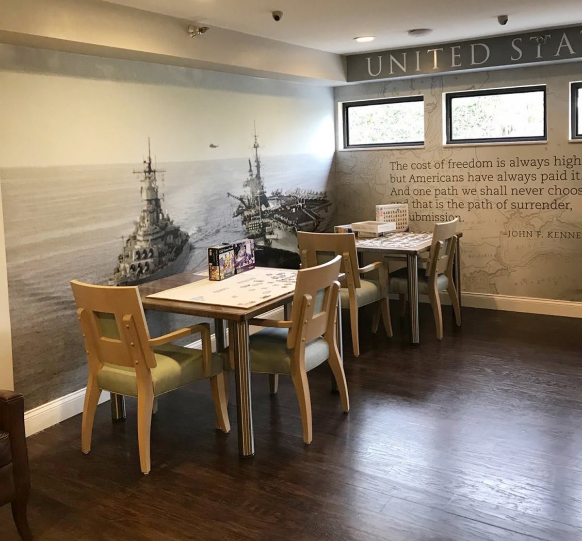 A cozy restaurant interior with neatly arranged tables and chairs, featuring artistic wall decor.