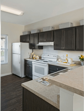 A modern kitchen with dark cabinets and white appliances.