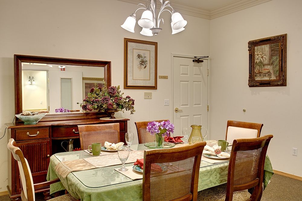 A cozy dining room with a beautifully set table and elegant chandelier lighting.