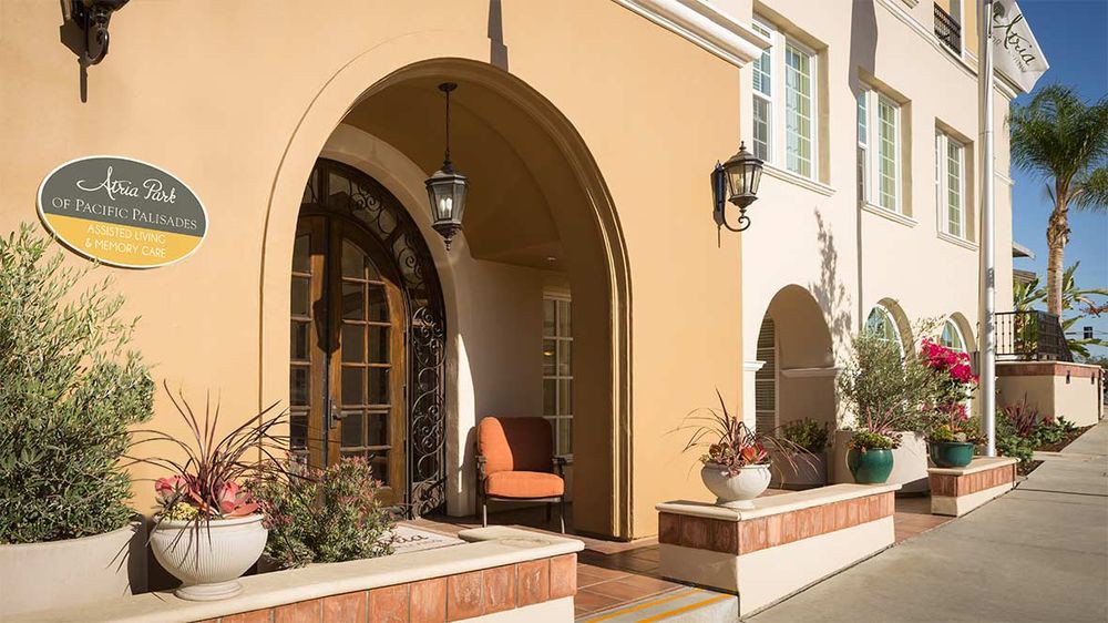 A welcoming entrance with archways, featuring a comfortable chair and decorative plants.