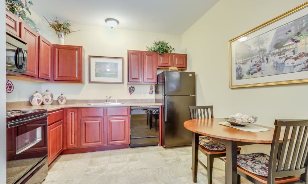 A cozy kitchen with wooden cabinets and a small dining area.