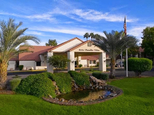 A serene view of a hotel with lush landscaping and a clear blue sky.