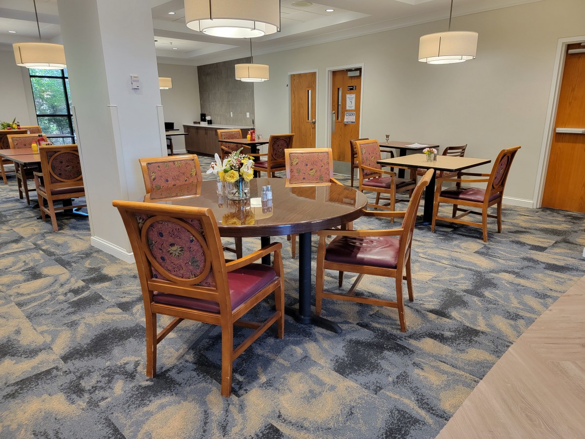 A well-lit dining area with a table and chairs, featuring stylish interior design elements.