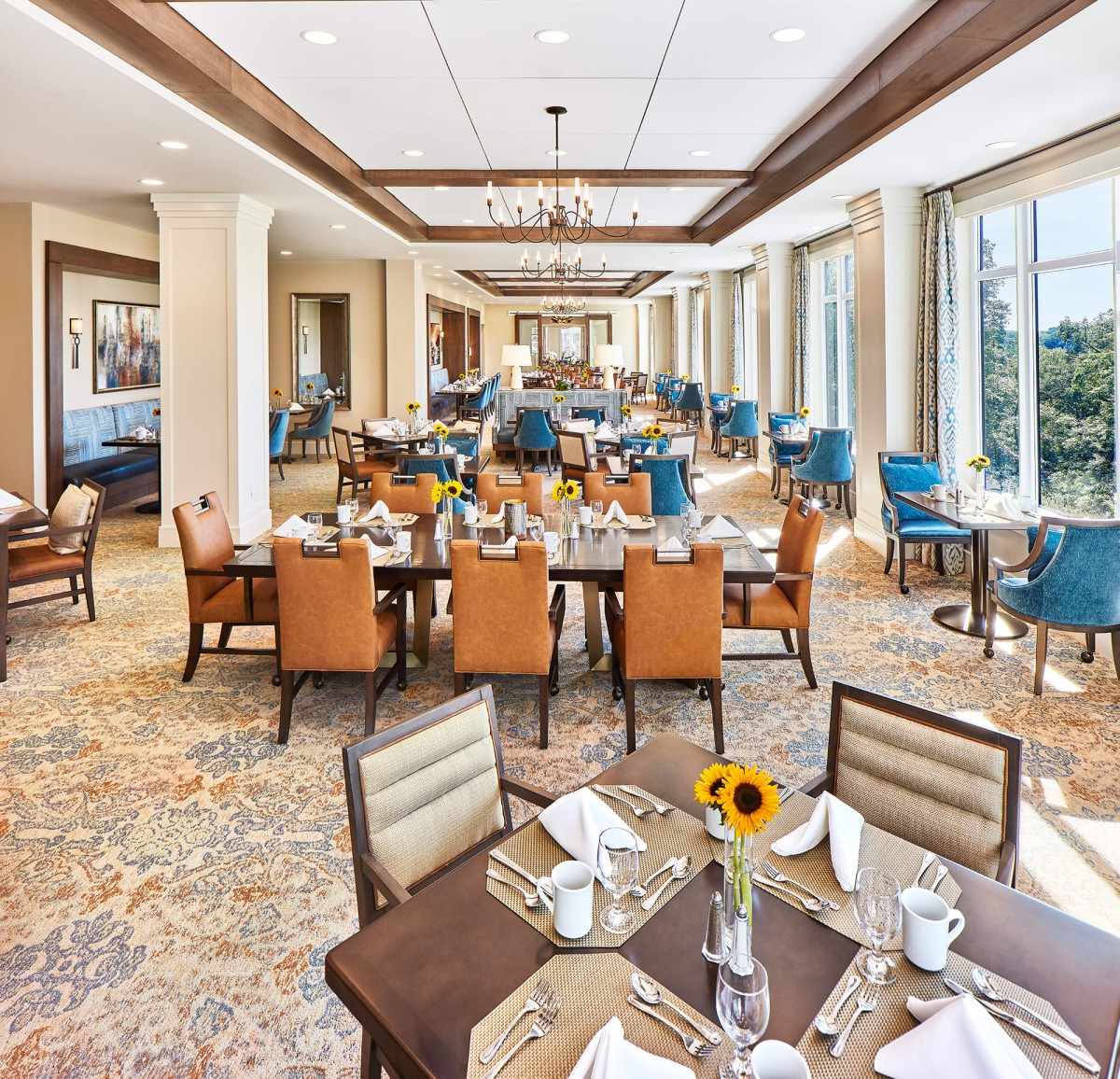 An elegant dining room with neatly arranged tables and chairs, featuring large windows and stylish decor.