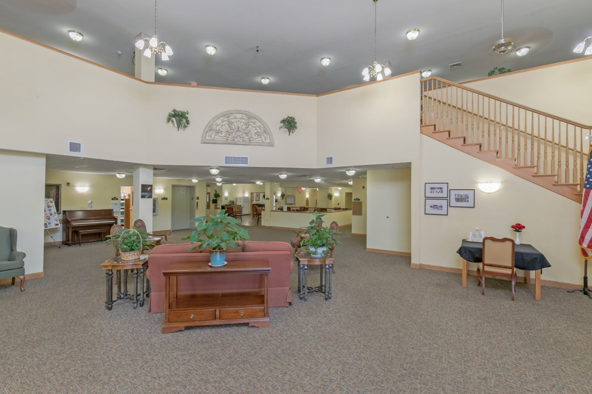 A spacious lobby with a reception area, featuring comfortable seating and decorative plants.