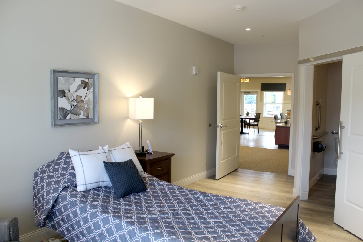 A modern bedroom with a neatly made bed and minimalist decor.