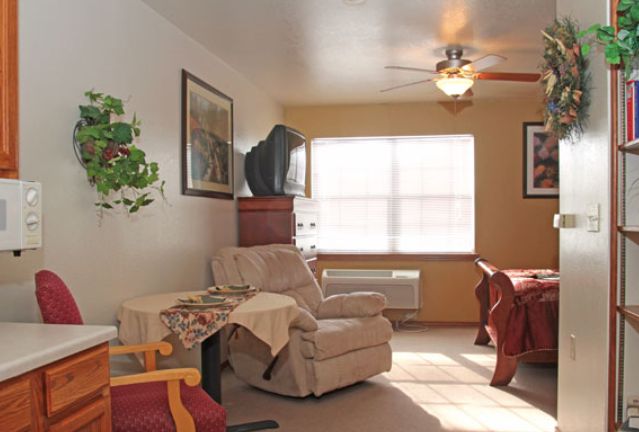 A cozy living room with comfortable seating, a TV, and natural light.