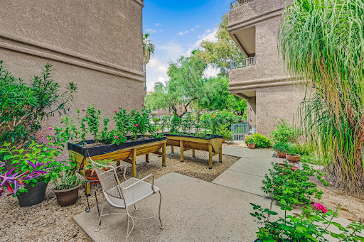 A beautifully landscaped garden area equipped with raised vegetable beds and seating, perfect for enjoying nature.
