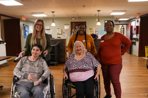 A joyful moment captured with caregivers and residents in an assisted living facility.