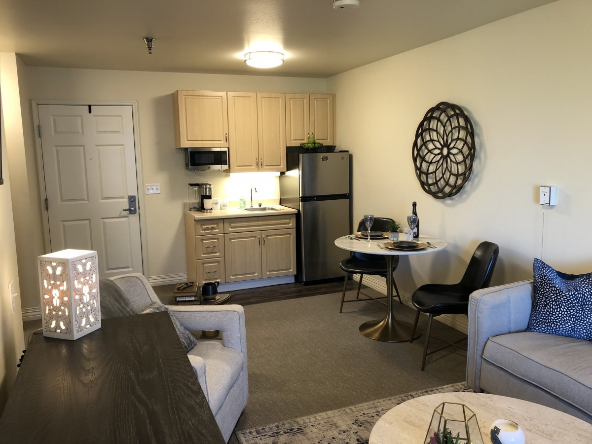 A cozy studio apartment with a small kitchen and modern decor.