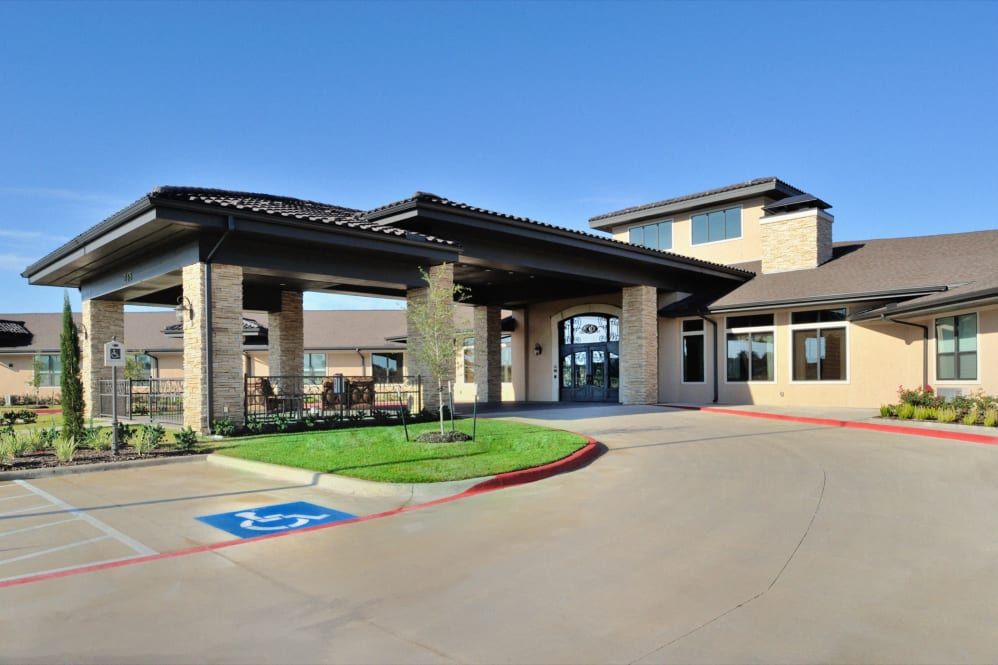 A modern building entrance with accessible parking space on a clear day.