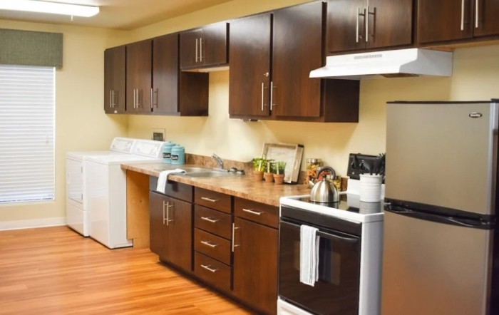 A modern kitchen with dark wooden cabinets and standard appliances.