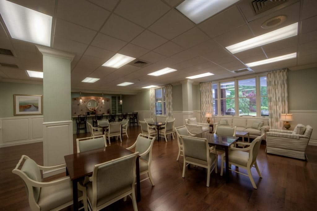 A well-lit dining room with chairs and tables arranged neatly.