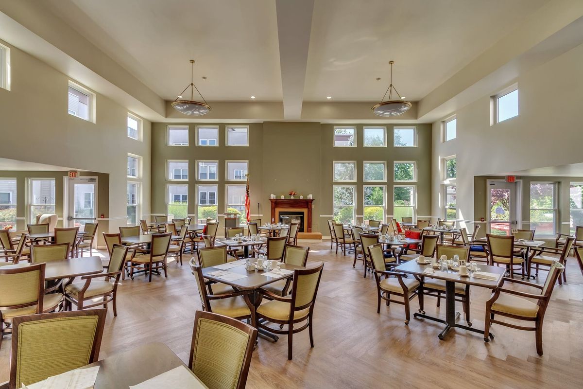 A spacious and well-lit dining area with neatly arranged tables and chairs.