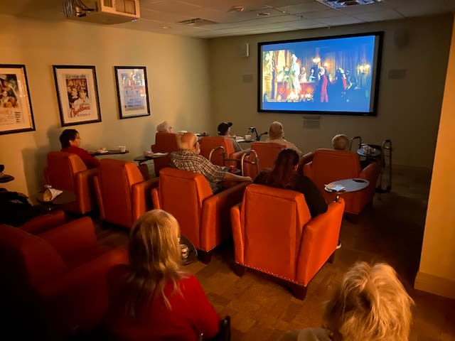 A small group of people watching a movie in a cozy screening room.