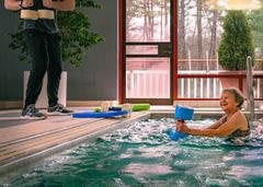 A person participates in aquatic therapy inside an indoor pool facility.