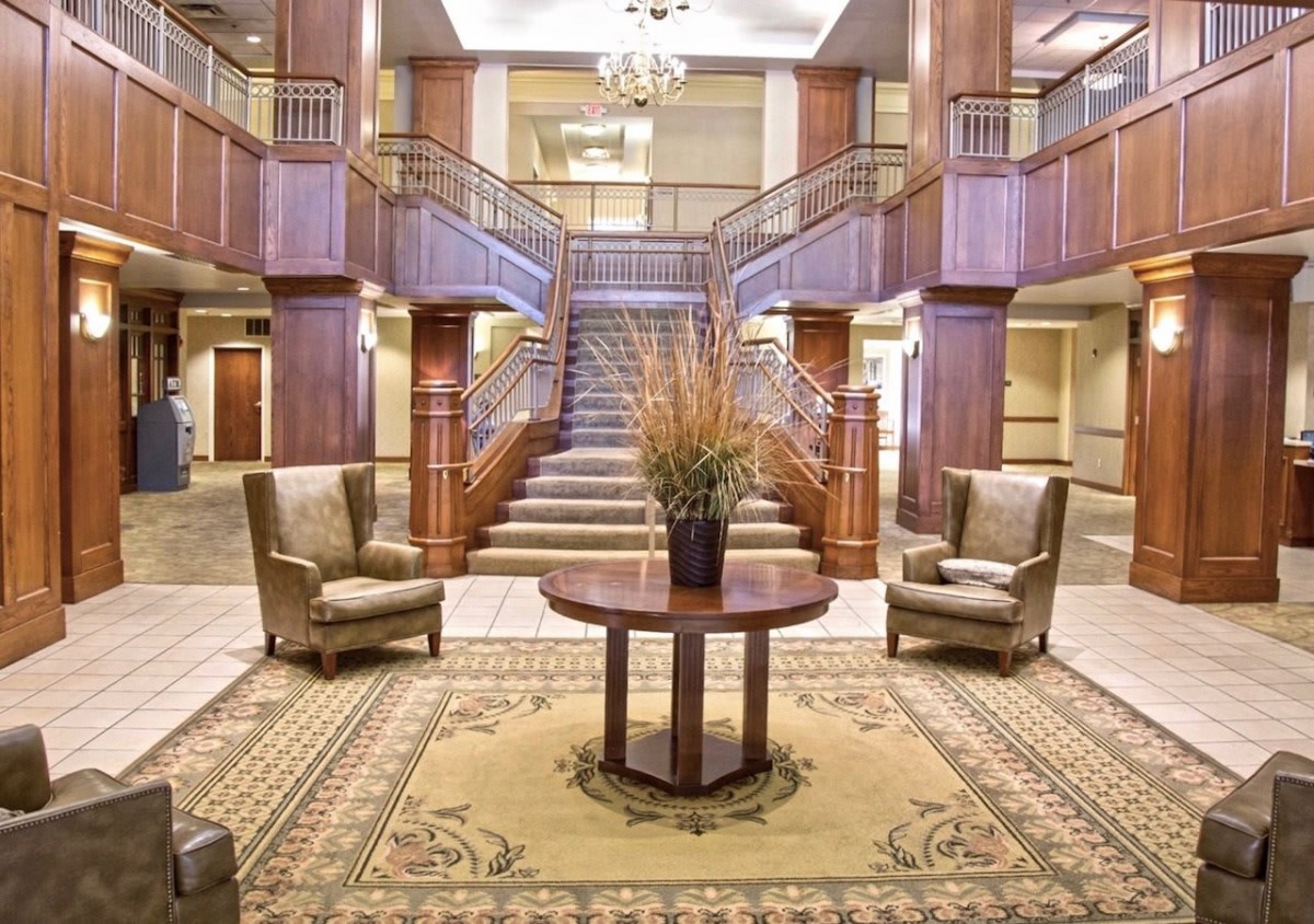 Elegant hotel lobby with a grand staircase and comfortable seating.