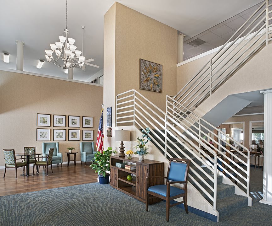 A modern lobby with seating area, decorative lighting, and a staircase.