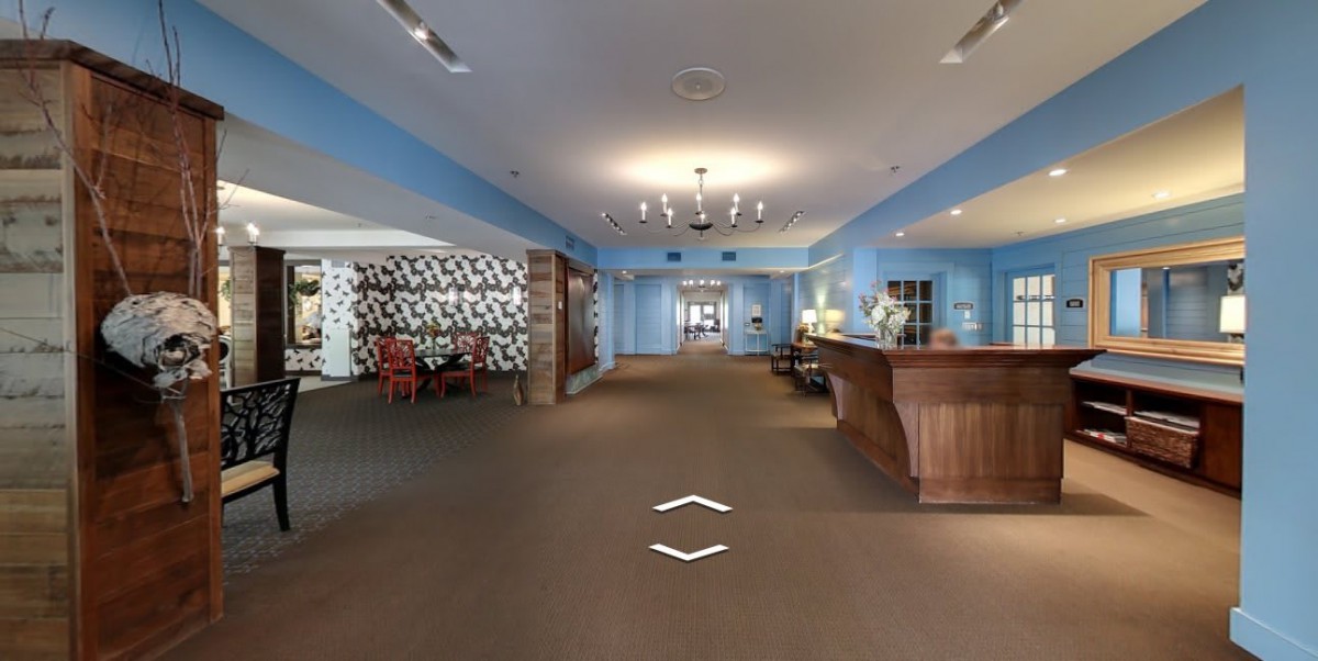 Modern hotel lobby with a reception desk and seating area.