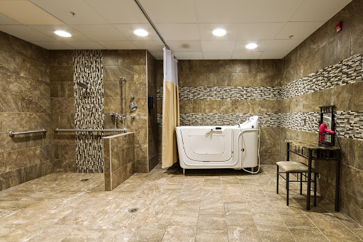 A modern and serene bathroom space featuring a therapy tub and elegant tiled walls.