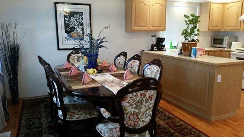 A cozy dining room with a floral-themed table setting and decorative artwork.