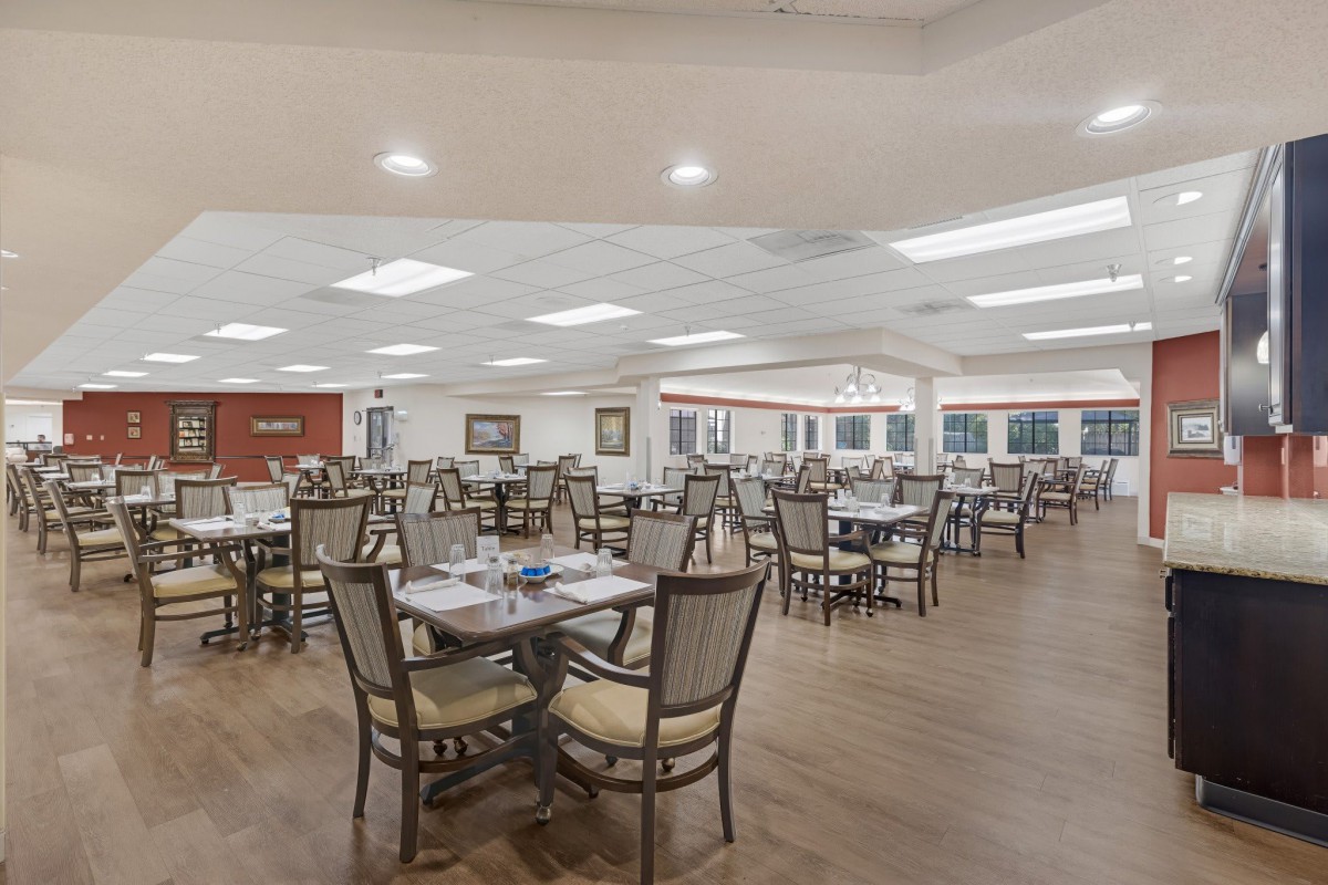 An empty restaurant dining room with neatly arranged tables and chairs.