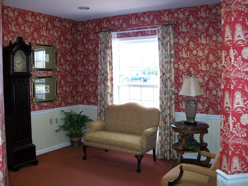 A cozy living room featuring floral wallpaper, a comfortable sofa, and elegant decor.