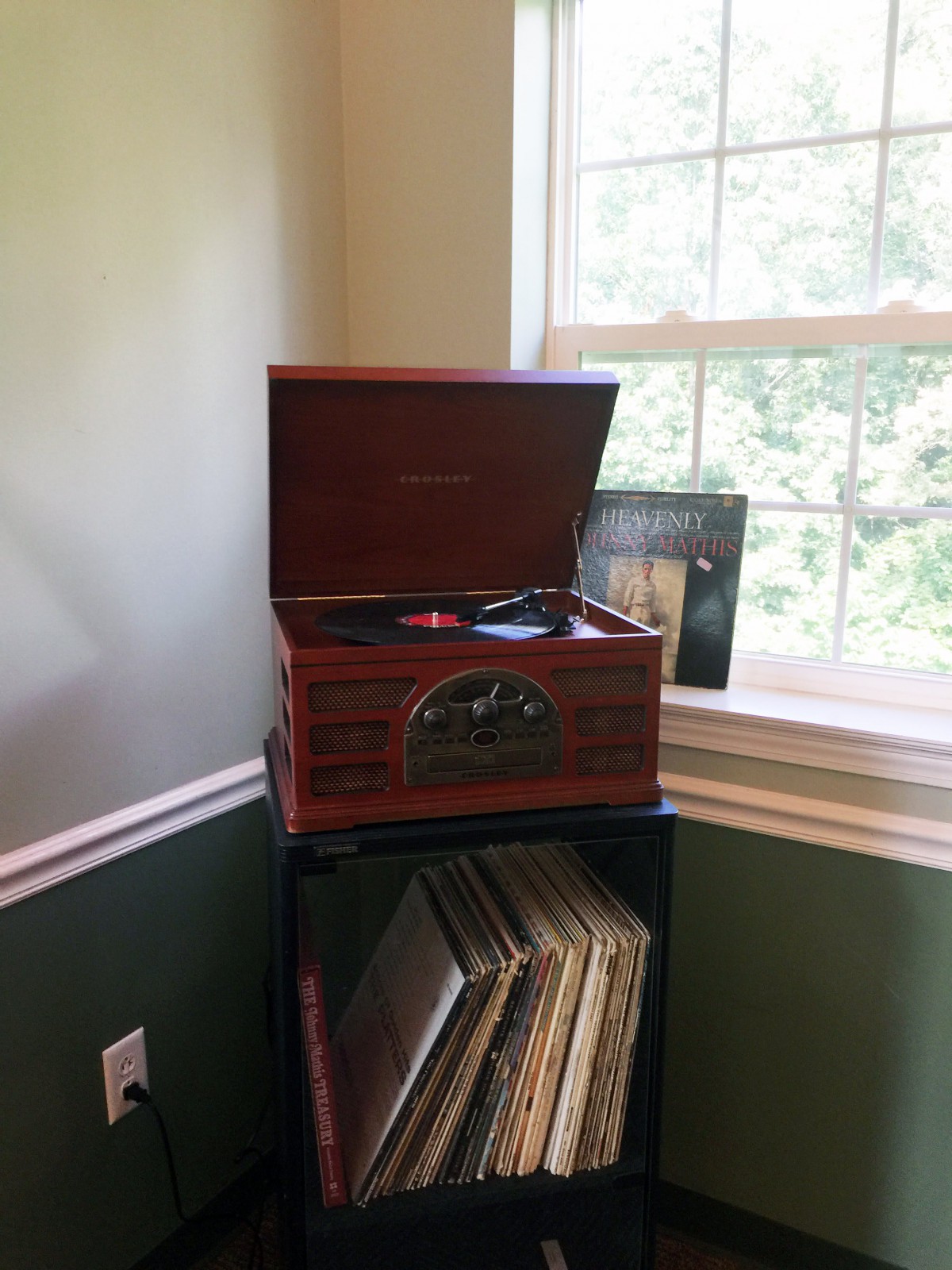 A vintage record player with a collection of vinyl records in a cozy corner.
