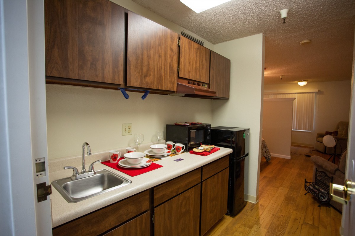 A cozy kitchen with wooden cabinets and a clean countertop.