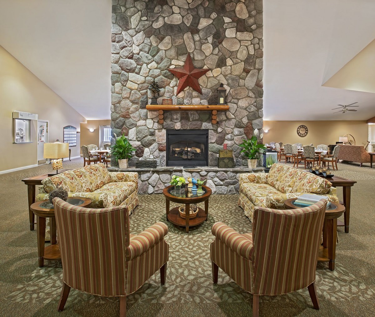 A cozy living room with a stone fireplace and comfortable seating.