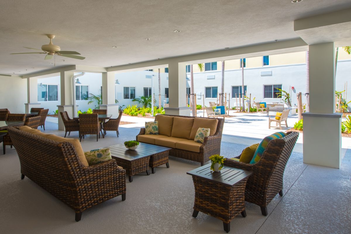 A cozy outdoor seating area with wicker furniture on a covered patio.