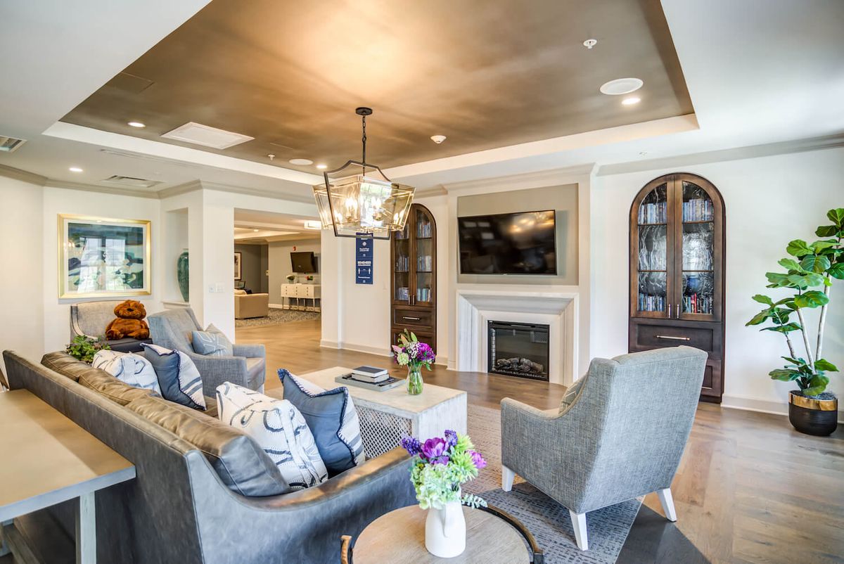 A stylish living room featuring a cozy seating area, modern fireplace, and elegant chandelier.
