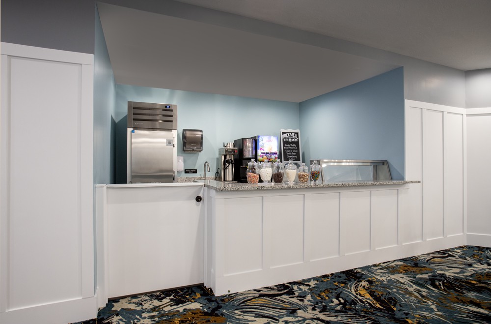 A hotel lobby beverage station equipped with a coffee machine and ice dispenser.