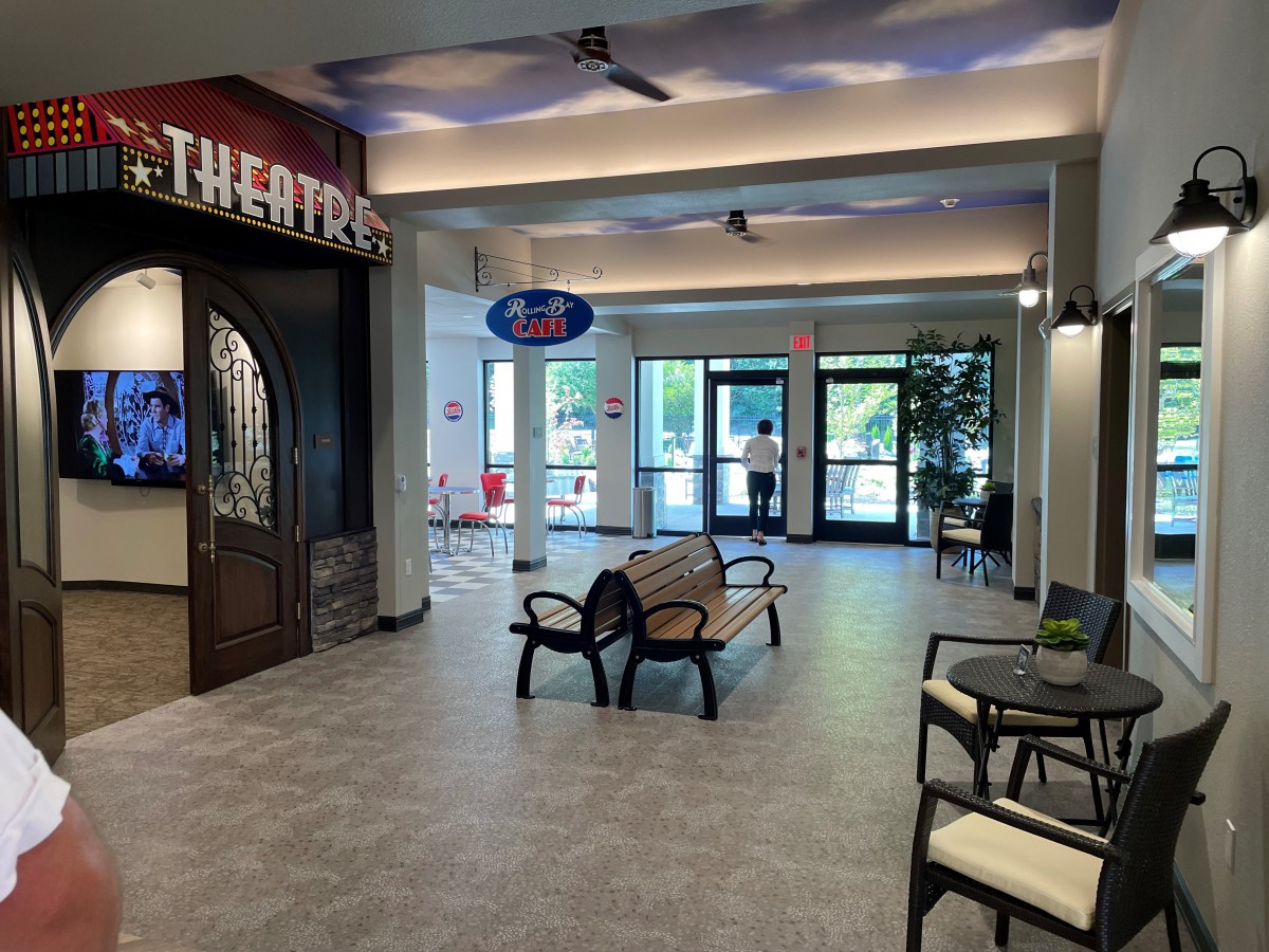 A modern waiting area with comfortable seating and a theater entrance.