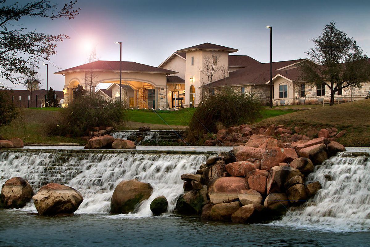 A beautiful evening view of a building with a waterfall in the foreground.