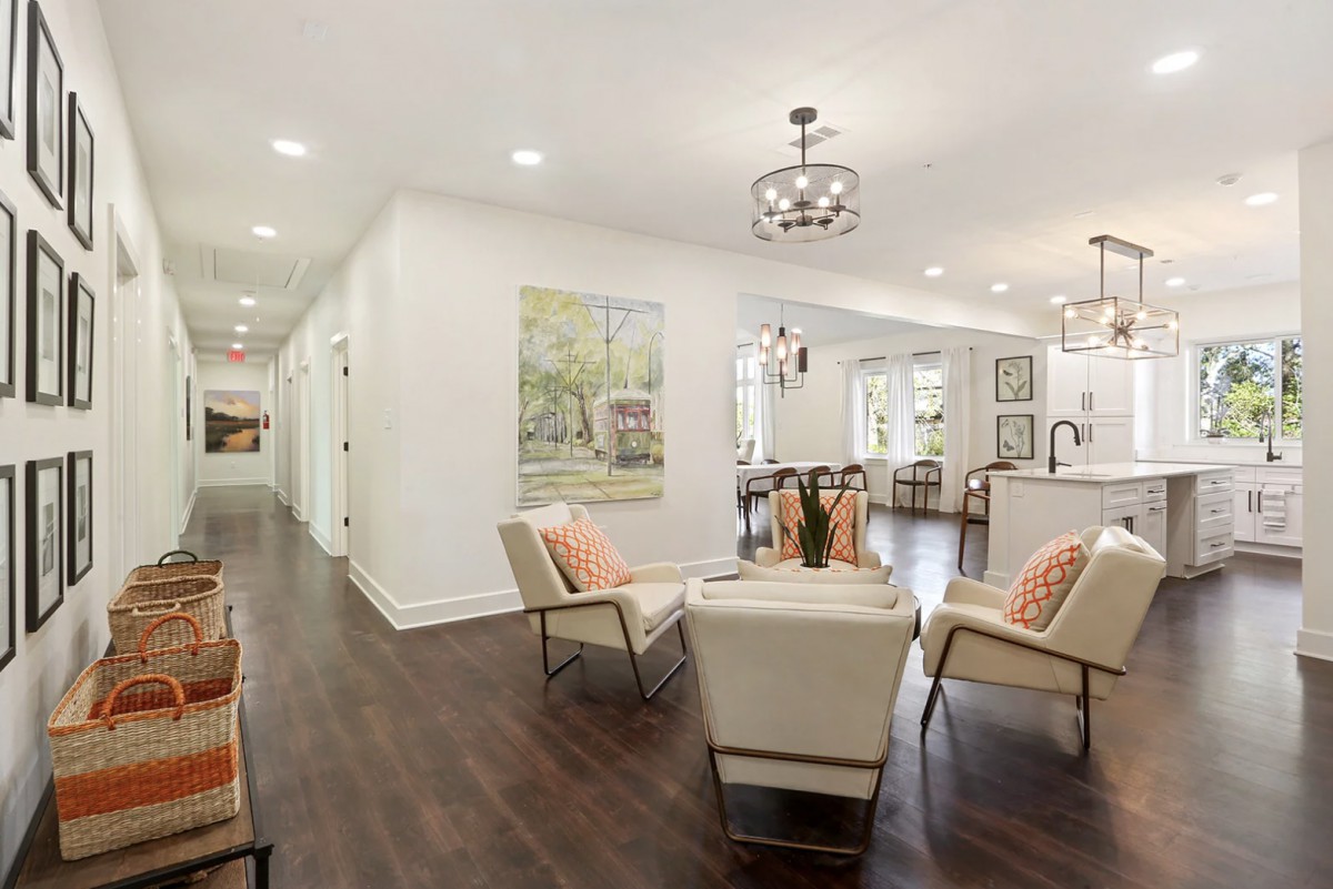 A modern living space with an open layout, featuring stylish furniture and wood flooring.