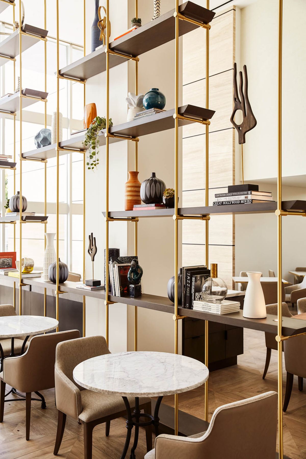 A stylish modern cafe interior with decorative shelving and contemporary furniture.