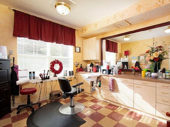 A cozy barber shop interior with hair styling equipment and a decorative mirror.
