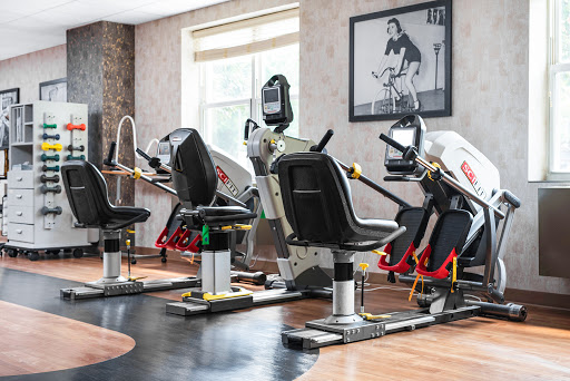 A modern gym setup featuring various exercise machines designed for strength training and cardio workouts.