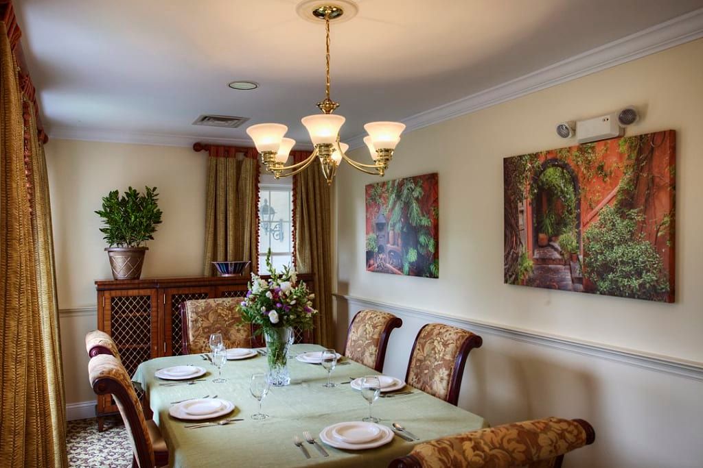 A beautifully set dining room with a chandelier and elegant decor.