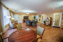 A cozy living room with seating, tables, and a television.