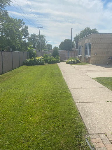 A well-maintained lawn and sidewalk beside a building on a sunny day.