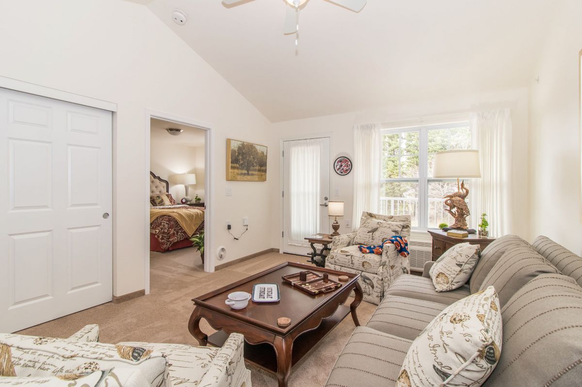A bright and cozy living room with floral patterned furniture and wooden accents.