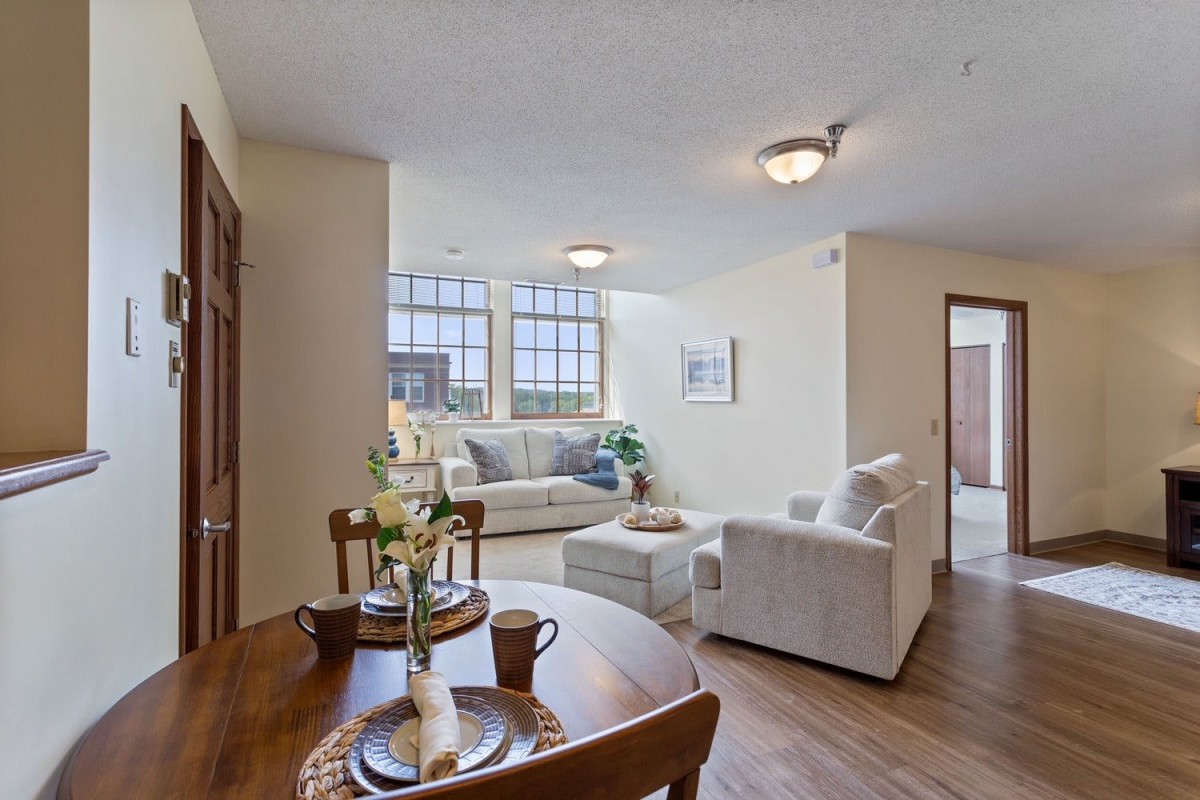 A modern living room and dining area with stylish furniture and large windows.