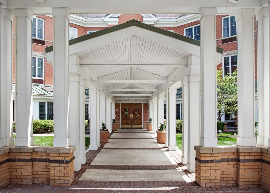A covered walkway leading to the entrance of a building with columns on either side.