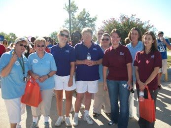 A group of people standing outdoors in casual clothing, likely attending an event.