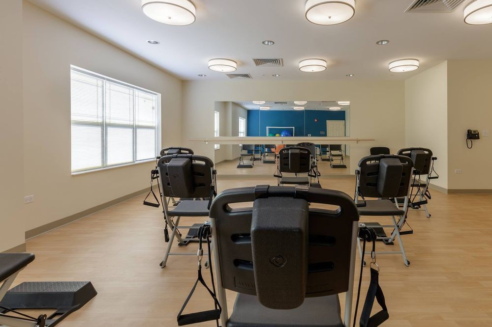 A rehabilitation room equipped with exercise machines and mirrors for physical therapy sessions.
